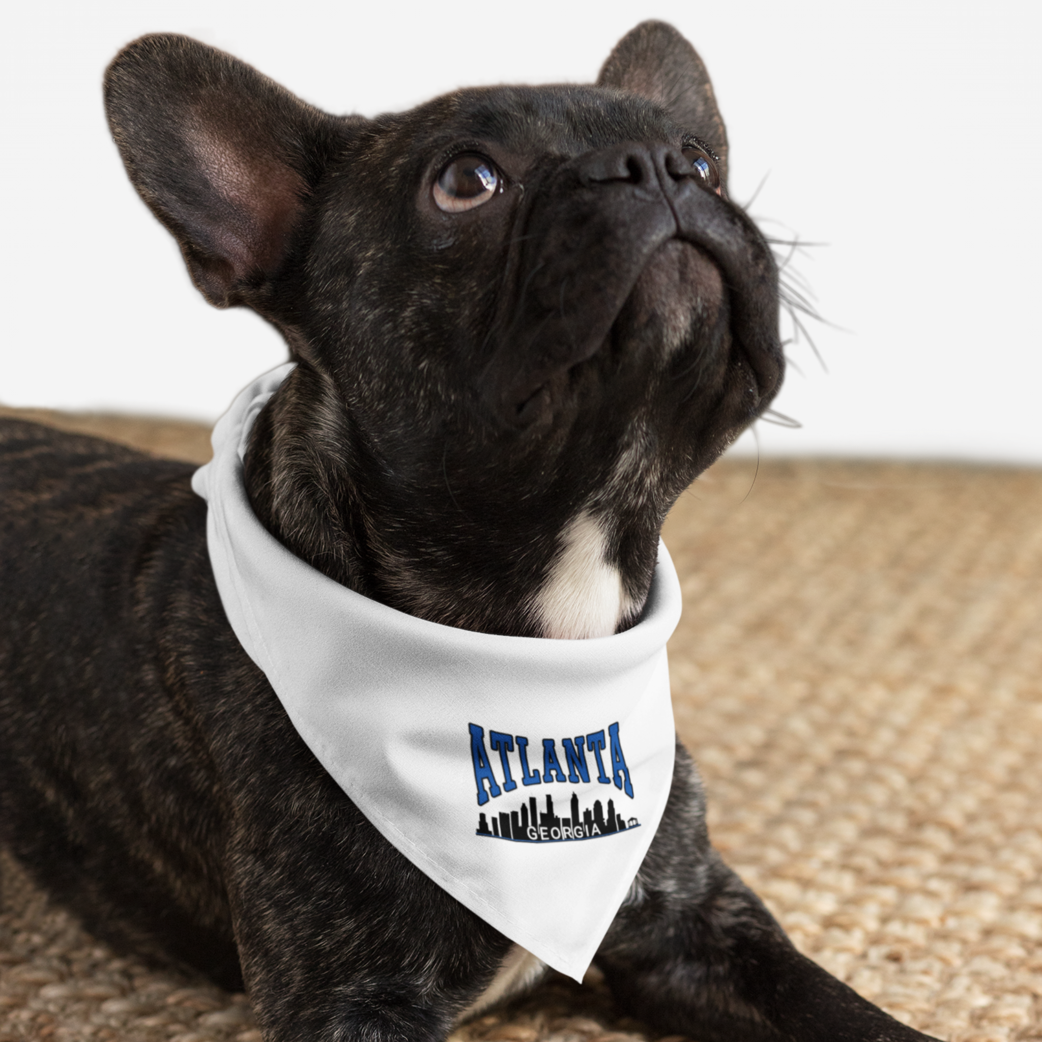 Dog wearing white bandana saying "Atlanta Georgia" along with a skyline silhouette.