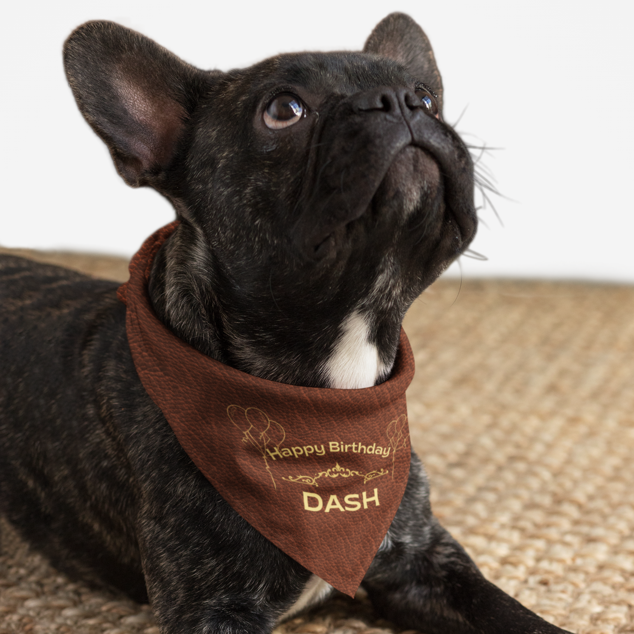 Dog wearing personalized name birthday bandana featuring gold Happy Birthday text on custom dark tan leather print effect background.