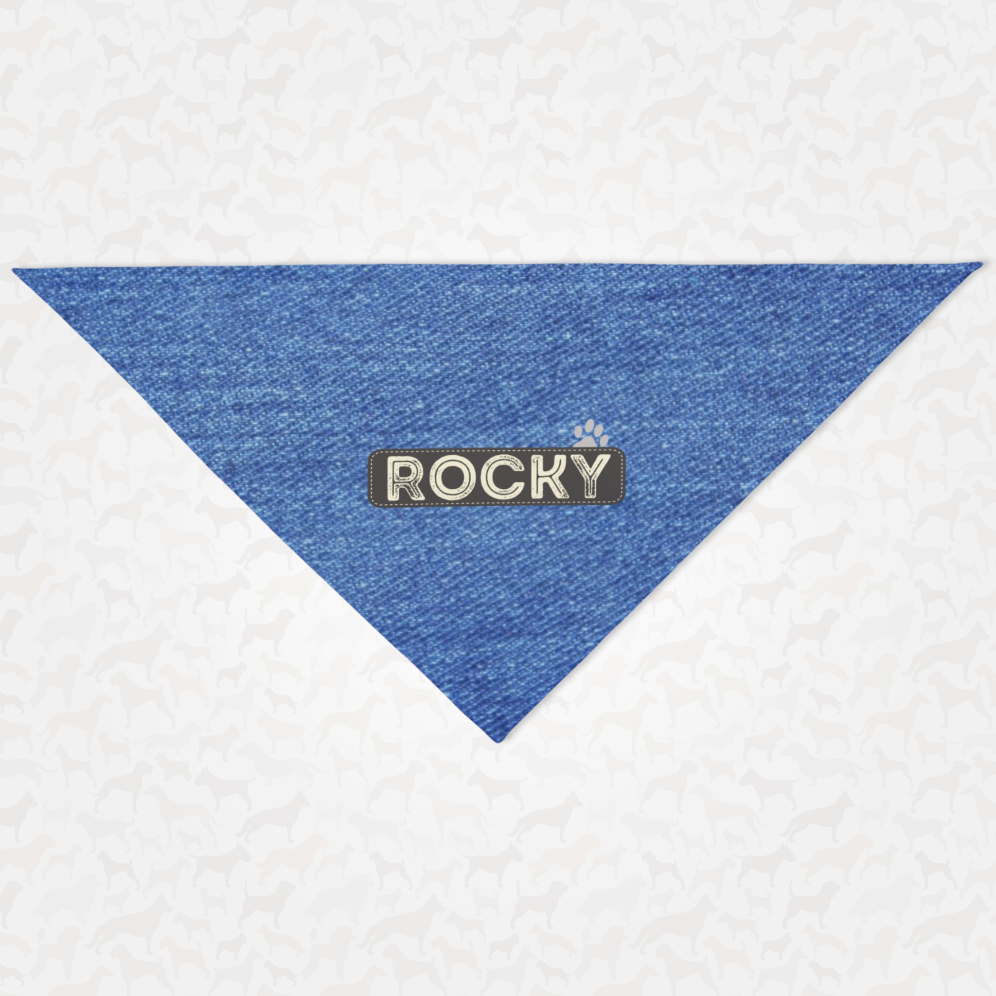 Personalized dog bandana featuring name on charcoal gray badge with denim print effect background.