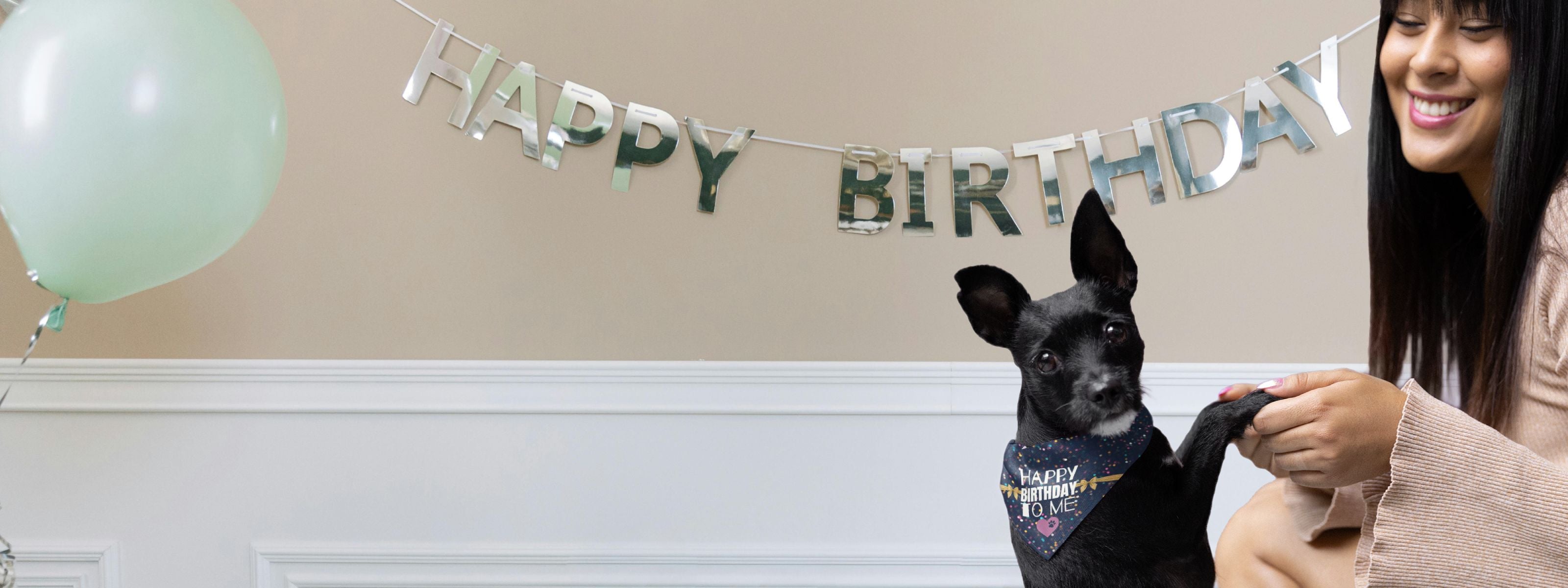 Woman celebrating dog birthday with bandana saying Happy Birthday To Me.